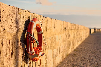 Orange Lifebuoy on Stone Wall at Golden Hour