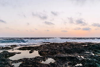 Rugged Rocky Coastline with Crashing Waves at Sunset