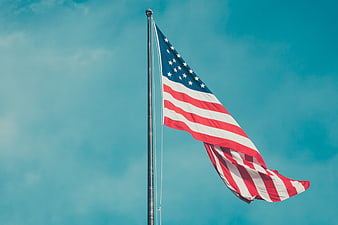 American Flag Waving Against Blue Sky Background