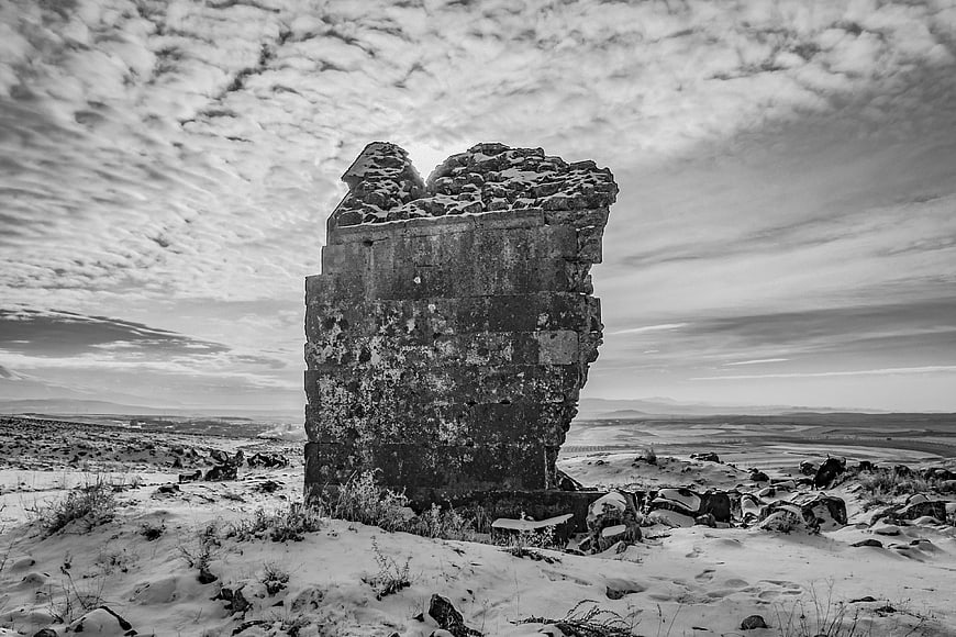 Ancient stone ruin standing in snowy winter landscape