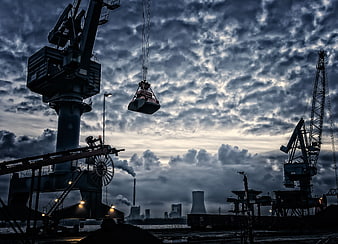 Dramatic Industrial Port Cranes Silhouetted Against Stormy Twilight Sky