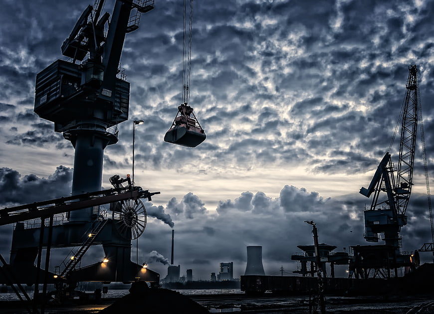 Dramatic Industrial Port Cranes Silhouetted Against Stormy Twilight Sky