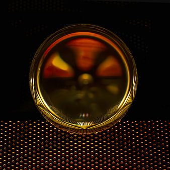 Golden glass sphere on perforated metal background