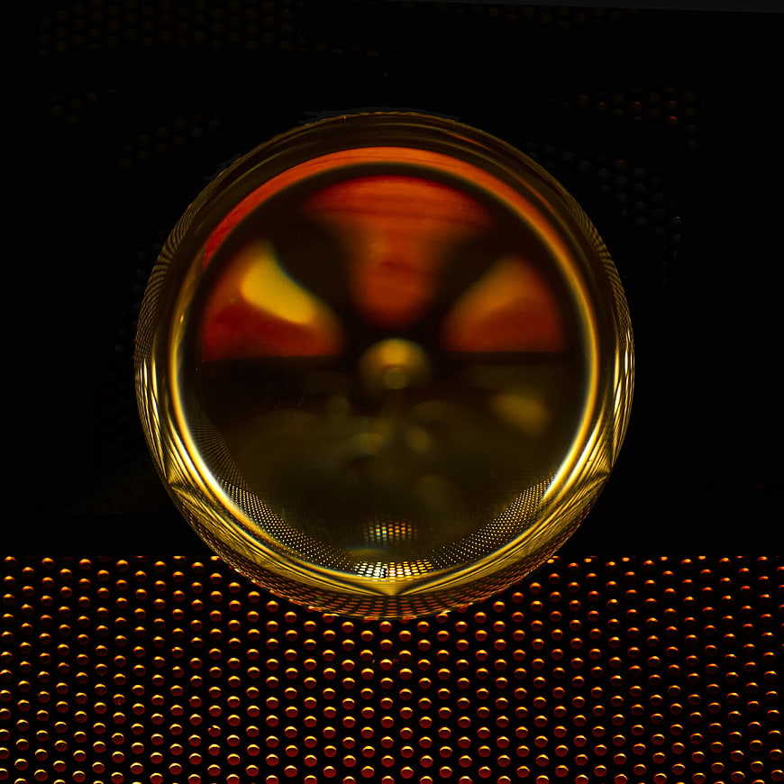 Golden glass sphere on perforated metal background