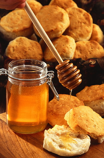 Honey Drizzled On Fresh Biscuits With Glass Jar