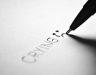 Pen writing crying word and sad face on paper