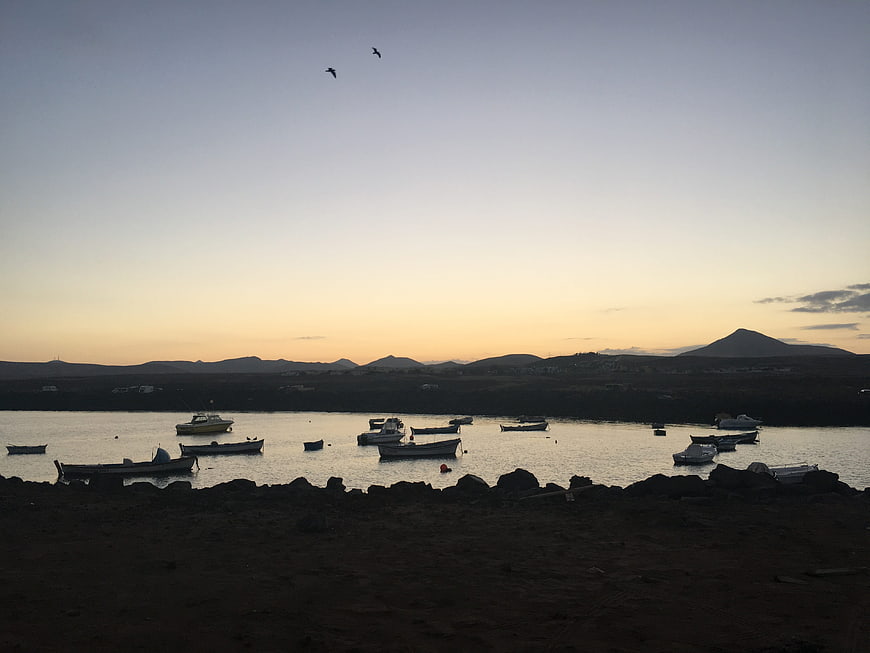 Silhouetted Fishing Boats in Harbor at Sunset