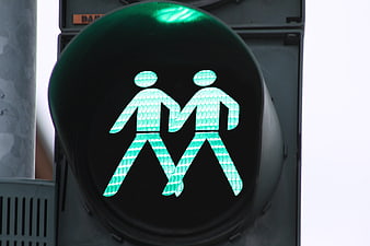 Green pedestrian traffic light with two walking figures