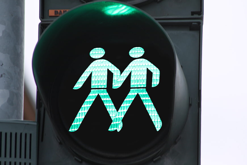 Green pedestrian traffic light with two walking figures