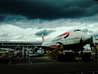 British Airways Boeing 747 at Airport Gate Under Stormy Sky