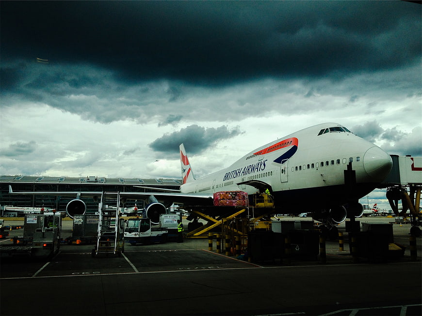 British Airways Boeing 747 at Airport Gate Under Stormy Sky