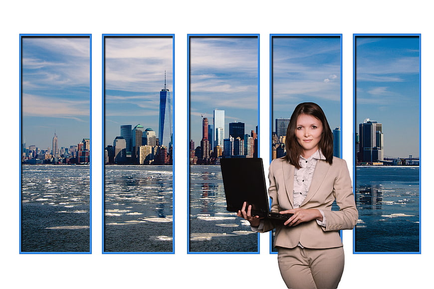 Professional Business Woman with Laptop in Front of New York City Skyline Windows