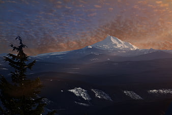 Snow-Capped Mountain Peak at Sunset with Dramatic Clouds