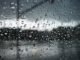 Close-up of Raindrops on a Blurred Car Window
