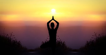 Silhouette of woman doing yoga at sunset