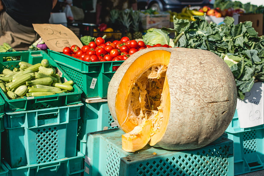 Fresh pumpkin and vegetables at an outdoor farmers market