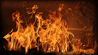 Vibrant orange flames burning in a rustic stone fireplace