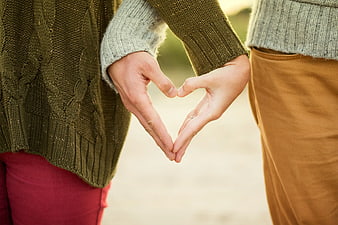 Couple Making Heart Shape with Hands in Knit Sweaters