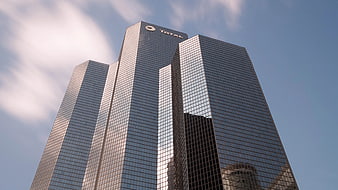 Low Angle View of Modern Glass Skyscraper Against Blue Sky