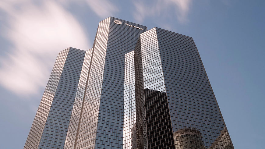 Low Angle View of Modern Glass Skyscraper Against Blue Sky