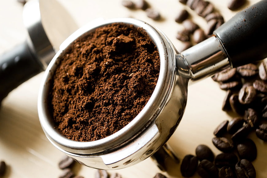 Ground Coffee in Portafilter with Roasted Beans