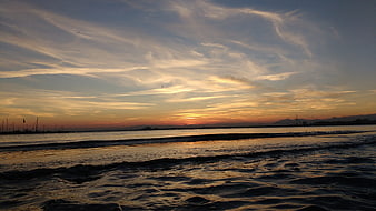 Serene Sunset Over Calm Sea with Silhouetted Sailboats
