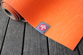 Orange Yoga Mat Rolled On Weathered Wooden Deck