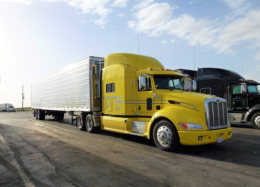 Yellow Peterbilt Semi-Truck With Refrigerated Trailer In Parking Lot