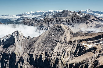 Majestic Alpine Mountain Range with Clouds and Snowy Peaks