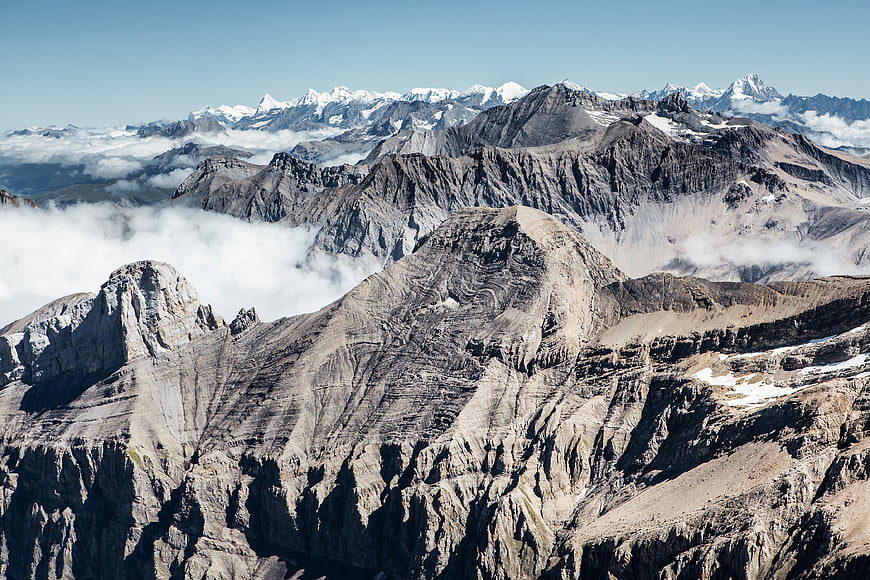 Majestic Alpine Mountain Range with Clouds and Snowy Peaks