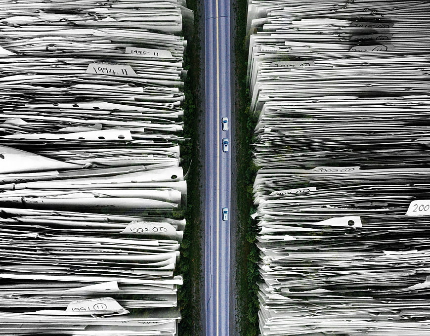 Aerial View of Road Flanked by Massive Stacks of Paper Documents