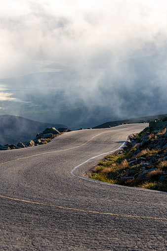 Winding Mountain Road Through Misty Clouds