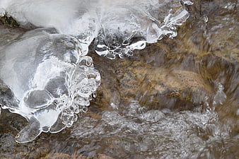 Frozen Ice Formations on Flowing Stream Rocks