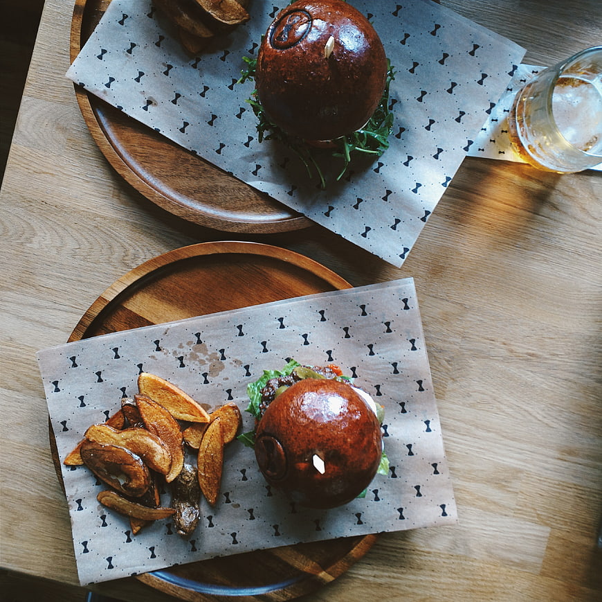 Top view of gourmet burgers with potato wedges on wooden table