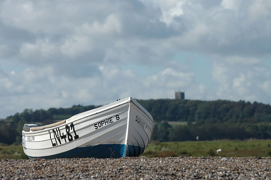 White and Blue Fishing Boat on Pebble Beach