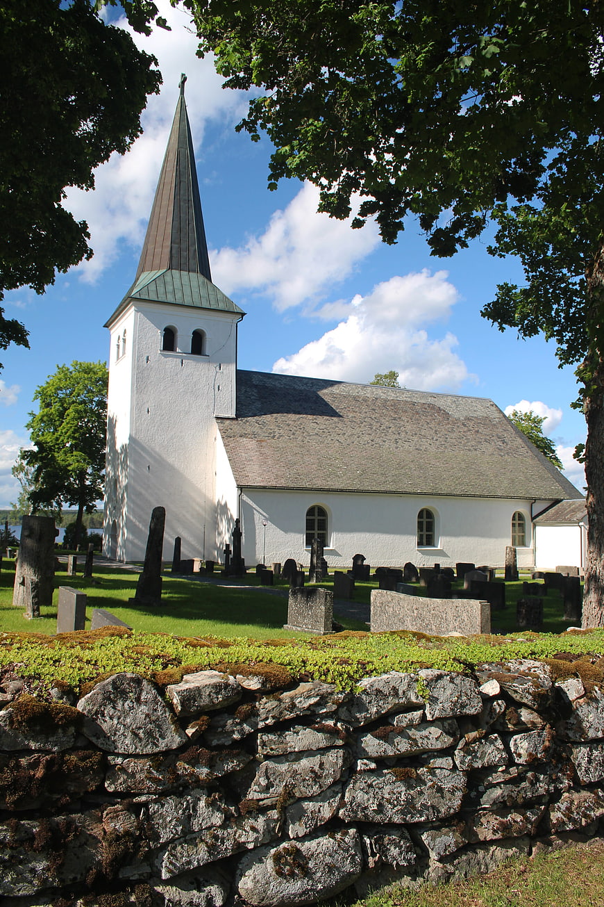 White Swedish Church with Spire and Stone Wall