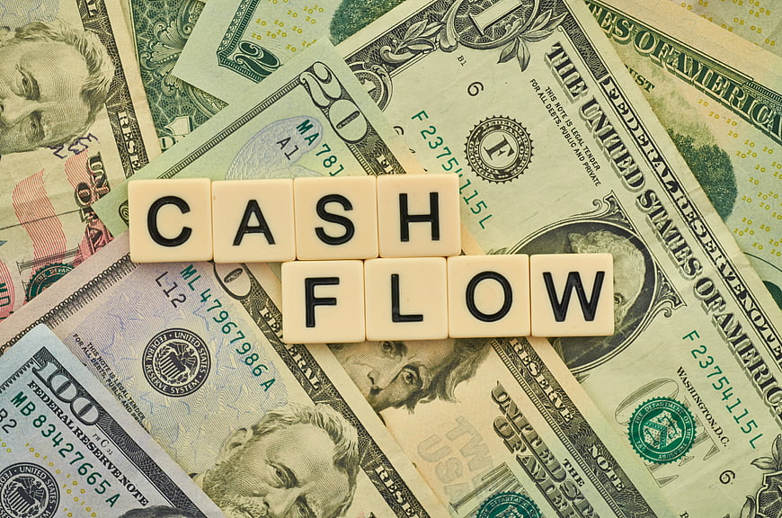 Cash Flow Word Spelled with Letter Tiles on US Dollar Bills