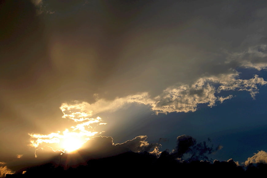 Dramatic sunset with sun rays breaking through clouds