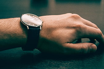 Close-up of a man's wrist wearing a minimalist silver watch