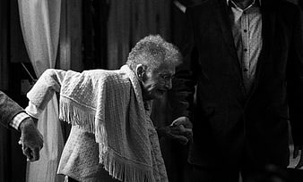 Senior woman walking with assistance in black and white
