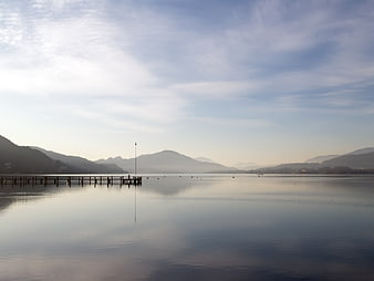 Serene Lake Landscape with Wooden Pier and Misty Mountains
