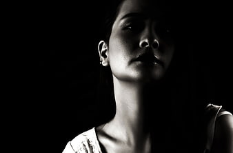 Dramatic black and white portrait of a woman in shadow