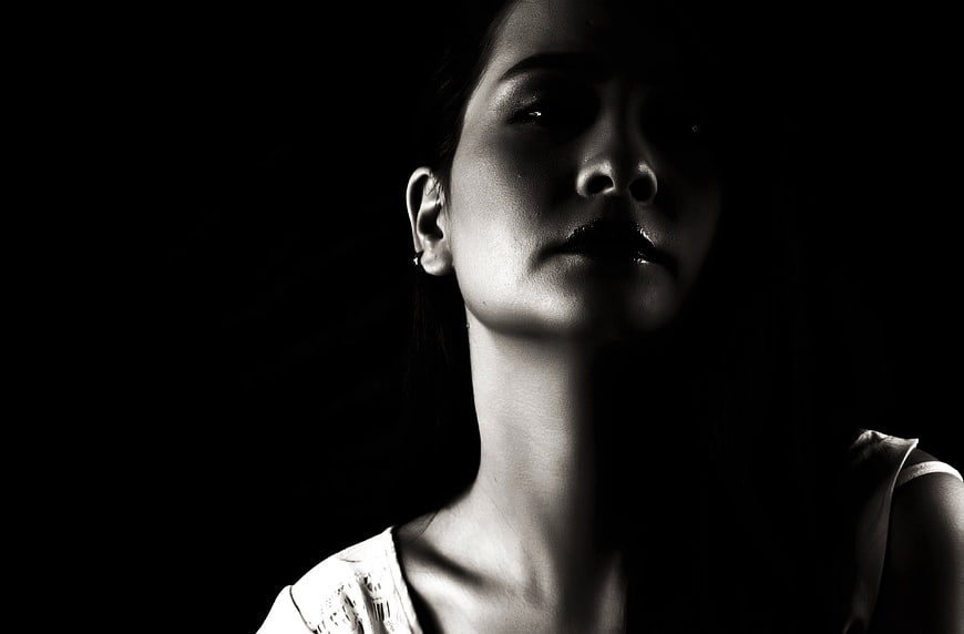 Dramatic black and white portrait of a woman in shadow