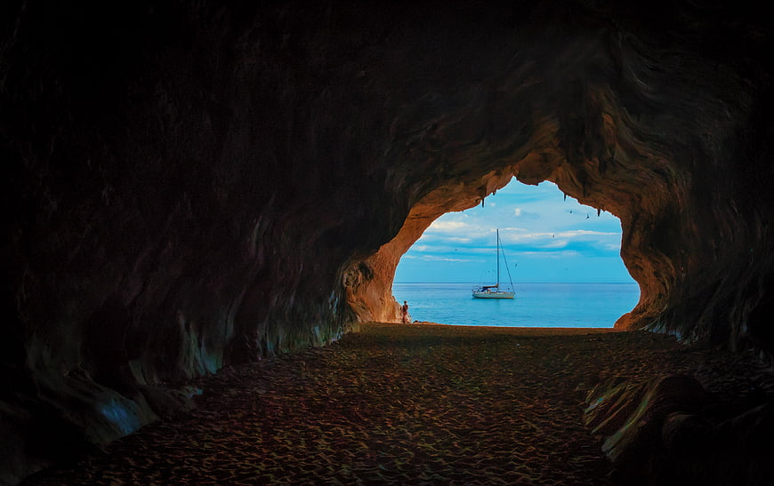 Sailboat Viewed Through Dark Sea Cave Archway