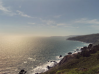 Sunlit Pacific Coastline with Rolling Hills and Ocean View