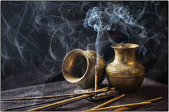 Traditional Indian Brass Incense Burners with Smoke on Dark Wood