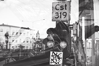 Black and white railway signal with reflections and graffiti