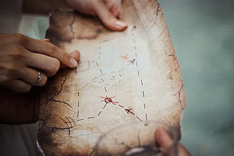 Hands Holding Vintage Treasure Map With Red X Mark