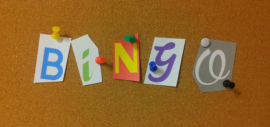 Bingo letters on colorful paper cards pinned to a corkboard