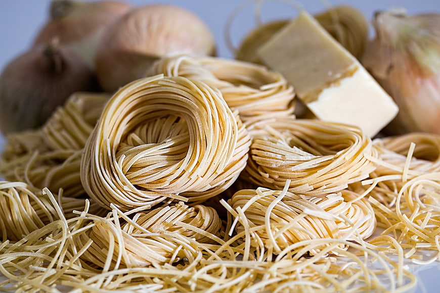 Uncooked spaghetti nests with onions and butter